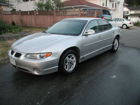 2002 Pontiac Grand Prix - This silver 2002 Pontiac Grand Prix is parked on a wet asphalt surface.