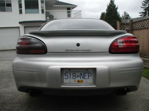 2002 Pontiac Grand Prix - The rear of a silver 2002 Pontiac Grand Prix is shown, its distinctive LED tail lights and a spoiler.