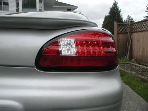 2002 Pontiac Grand Prix - Close-up of the rear tail light assembly on a silver 2002 Pontiac Grand Prix, showing the LED pattern and reverse light.