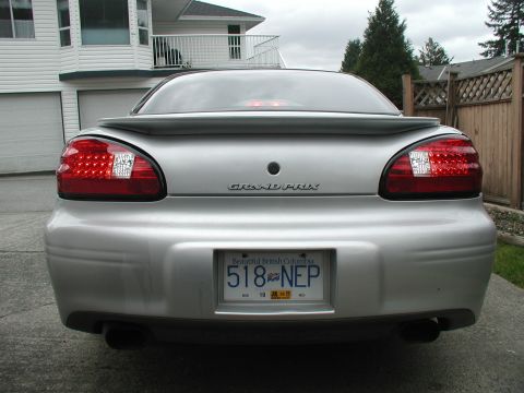 2002 Pontiac Grand Prix - The rear of a silver 2002 Pontiac Grand Prix is shown, its distinctive LED tail lights and a spoiler.
