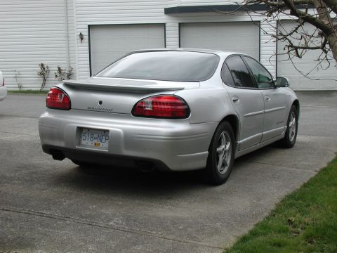 2002 Pontiac Grand Prix - Rear view of a silver 2002 Pontiac Grand Prix sedan parked in front of a garage.