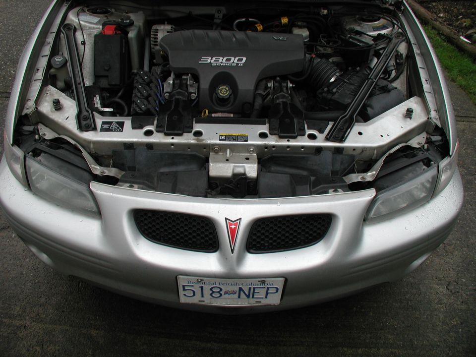 Silver Pontiac front end with headlights removed, showing 3800 Series II V6 engine bay