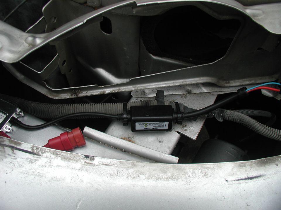 HID ballast with wiring harness and red connector, mounted in vehicle engine bay