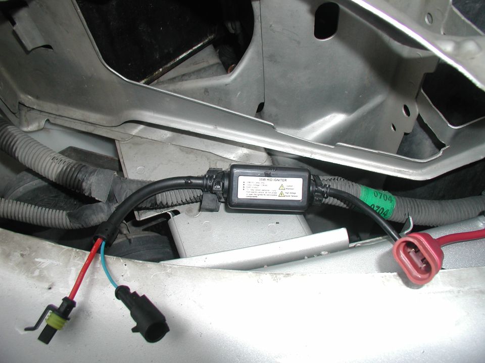35W HID igniter module and wiring harness laid in front core support of silver car