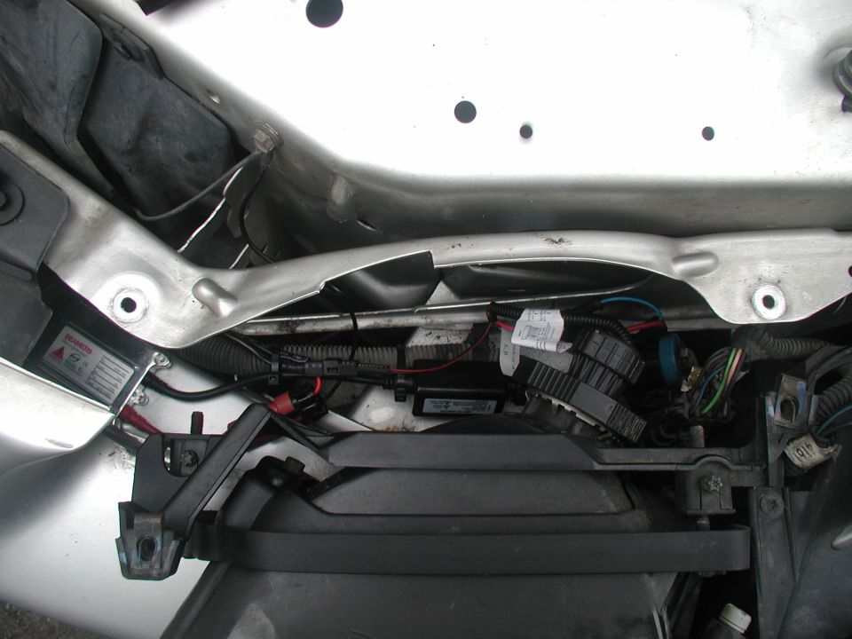 HID ballast and wiring mounted in front core support of silver car with headlight removed
