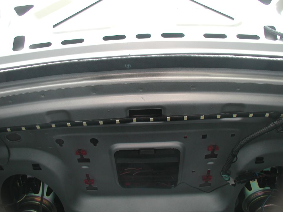 Unlit LED strip mounted along a car trunk opening lip with lid raised