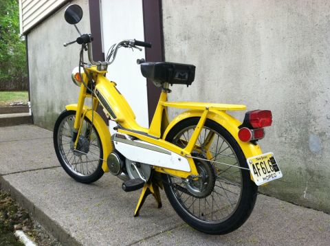 1981 Garelli Rally Sport - Yellow moped parked on a sidewalk next to a building. The license plate is from New Jersey.