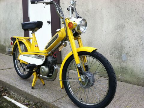1981 Garelli Rally Sport - A yellow moped is parked outside a building with a concrete wall.