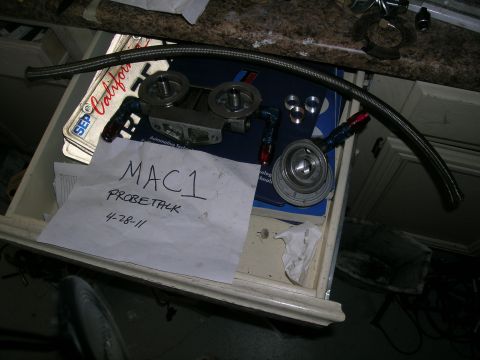 1995 Ford Probe - An oil filter housing and braided hose are laid out on a surface, with a handwritten note that reads 'MAC1 PROBETALK 4-28-11'.