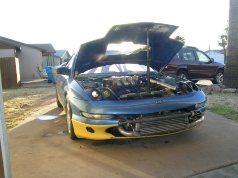 1995 Ford Probe - Front view of a 1995 Ford Probe with its hood open, revealing the engine bay and an intercooler.