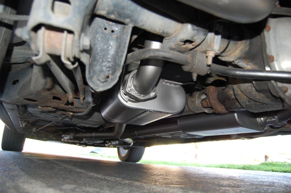 Underside view of a car's exhaust system with a new muffler installed