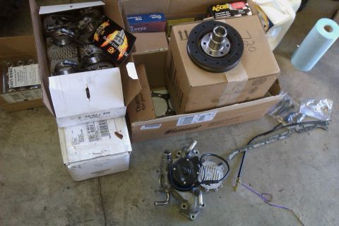 1996 Chevrolet Camaro - Various automotive parts are laid out on a concrete surface, suggesting a repair or upgrade project.