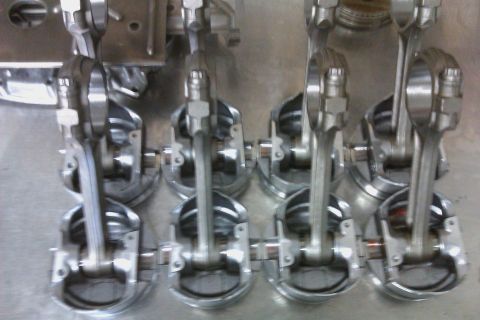 1996 Chevrolet Camaro - A collection of pistons and connecting rods are laid out, likely for an engine rebuild or modification.