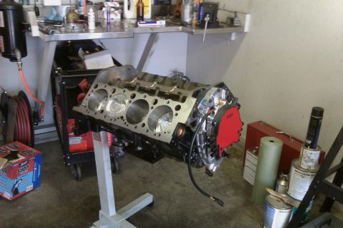 1996 Chevrolet Camaro - Engine block on a stand in a workshop setting, with various tools and supplies visible in the background.