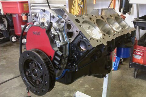 1996 Chevrolet Camaro - A disassembled engine block sits on a stand in a garage setting.