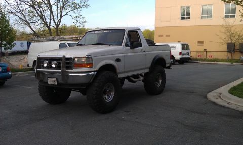 1996 Ford Bronco - This lifted 1996 Ford Bronco features a chrome grille guard and prominent off-road tires.