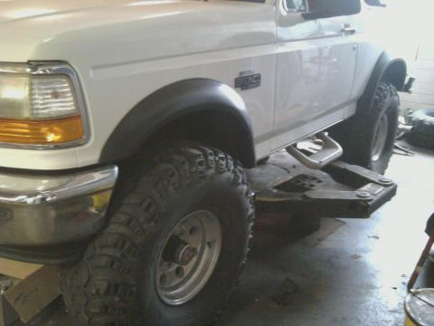 1996 Ford Bronco - Close-up of a 1996 Ford Bronco showing its front fender, tire, and running board.