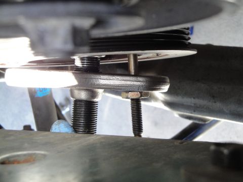 1995 Ford Taurus - A close-up view of a pulley system, showing threaded bolts and nuts, likely part of a vehicle's engine or accessory drive.