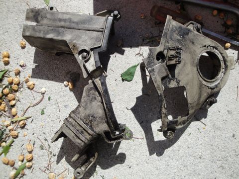 1995 Ford Taurus - Engine timing cover parts are shown lying on a concrete surface.