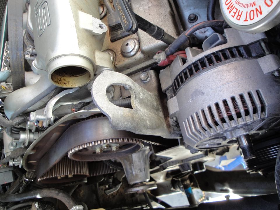 Close-up of car engine parts including alternator and timing belt