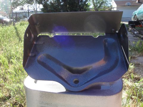 1995 Ford Taurus - A dark blue painted metal part is displayed on a silver base outdoors.