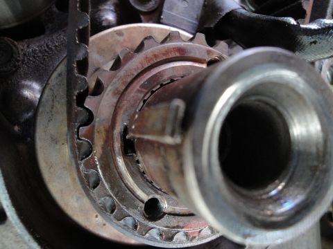 1995 Ford Taurus - This image shows a close-up view of a toothed pulley and a metal shaft, part of an engine's timing system.