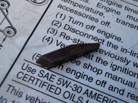 1995 Ford Taurus - A metal wedge rests on a document detailing engine maintenance procedures.