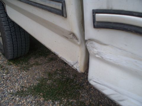 1992 Ford F-250 - Close-up of a damaged lower body panel and tire on a vehicle. The registry claims it is a 1992 Ford F-250, but this is not verifiable from…