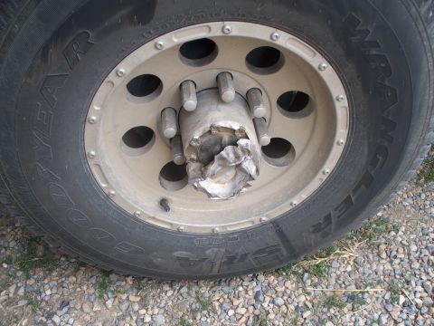 1992 Ford F-250 - The wheel hub on this truck has sustained significant damage, appearing bent and torn.