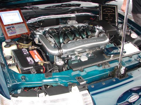 1992 Ford Taurus - The engine bay of a car, a prominent SHO 24 Valve DOHC engine cover and two display awards.
