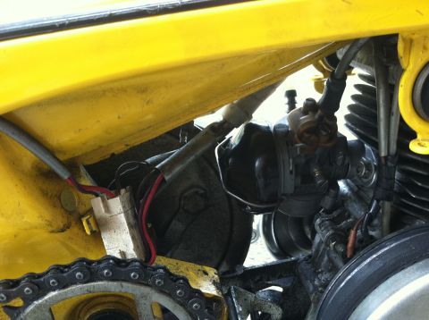 1981 Garelli Rally Sport - A close-up view of the engine components and drive chain of a yellow motorcycle.