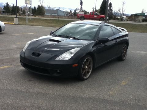 2006 Ford E350 - Black Toyota Celica with aftermarket wheels and a hood scoop.