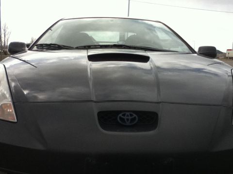 2006 Ford E350 - The front of a Toyota Celica is shown, a prominent hood scoop and the brand's emblem on the grille.