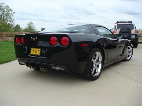 2006 Chevrolet Corvette - Rear view of a black 2006 Chevrolet Corvette, showing its distinctive taillights and quad exhaust pipes.