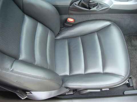 2006 Chevrolet Corvette - The interior of a car shows a black leather driver's seat with visible stitching and perforations.