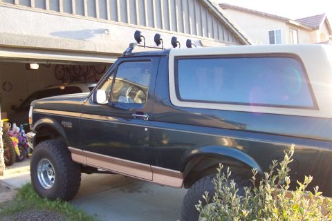 1995 Ford Bronco - Side view of a lifted Ford Bronco with a light bar and aftermarket wheels.