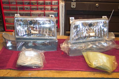 1995 Ford Bronco - New headlights and corner lights are laid out on a red towel, ready for installation.