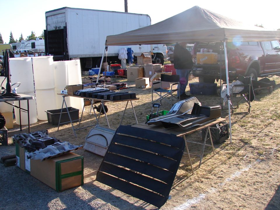 Car interior trim pieces and other parts displayed on tables at a market