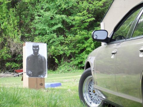 2000 Mercury Grand Marquis - A tan car is parked next to a target practice dummy in a grassy outdoor area.