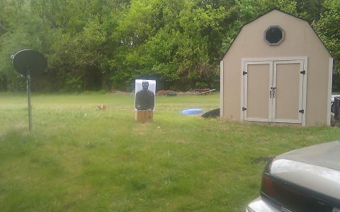 2000 Mercury Grand Marquis - Outdoor scene a target dummy, shed, and satellite dish, with a vehicle partially visible.