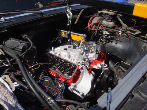 1989 Ford Bronco - Engine hoist is used to install a new engine into the vehicle's engine bay.