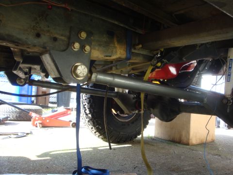 1989 Ford Bronco - Close-up view of modified vehicle suspension components and a tire.