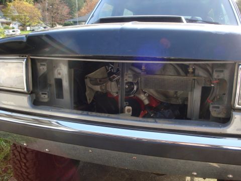 1989 Ford Bronco - Engine bay of a dark-colored truck with the front grille removed, showing the radiator and engine components.