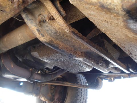 1989 Ford F-250 - Underside view of a rusty truck frame, showing exhaust and a tire. The year is not discernible.