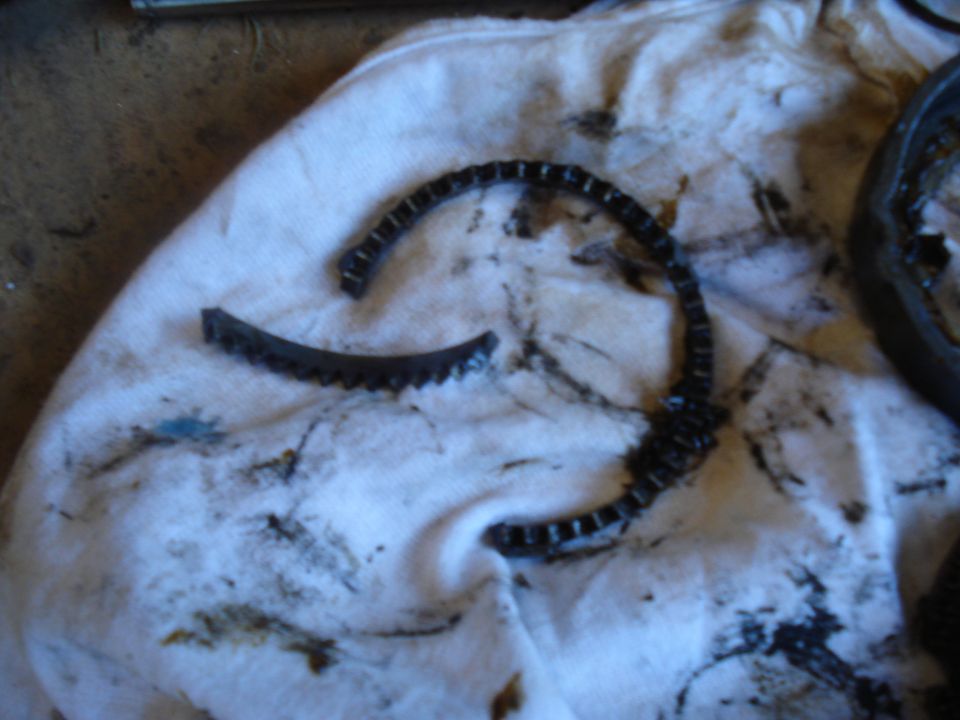Broken timing chain on white cloth with oil stains