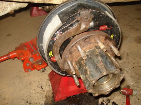 1989 Ford F-250 - A close-up view of a vehicle's brake drum and hub assembly, showing internal components and a red jack.