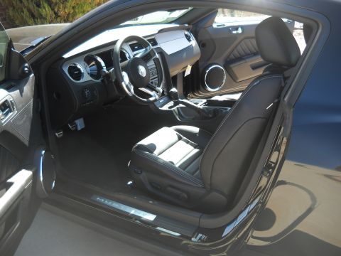 2012 Ford Mustang - The interior of a 2010 Ford Mustang features black leather seats and a modern dashboard layout.