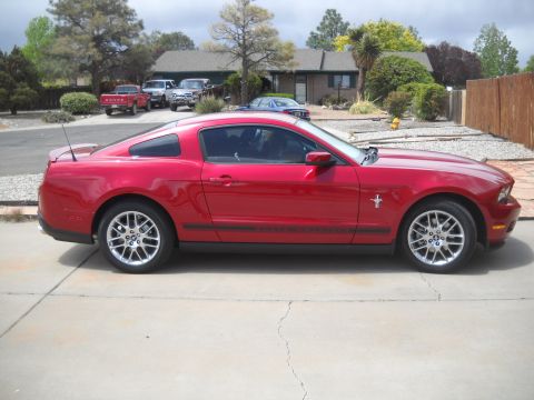 2012 Ford Mustang - A red Ford Mustang coupe is parked in front of a residential house.