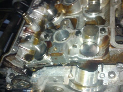 1995 Ford Probe - Close-up view of an engine's cylinder head, showing internal components and oil residue. The "Supermotors.net" watermark is visible.