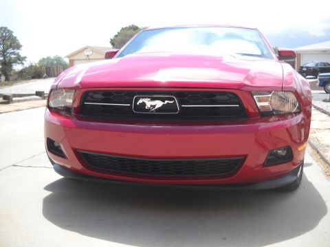 2012 Ford Mustang - Front view of a red Ford Mustang, showing the grille and headlights.